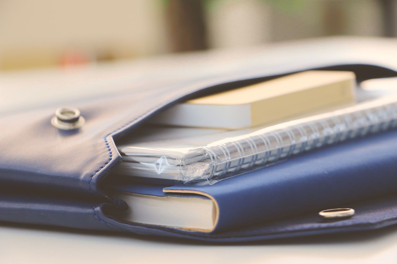 Services Close-up of a stylish blue portfolio containing various notebooks, creating an organized office look.